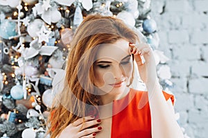 Christmas. Beautiful smiling woman Elegant over christmas tree in red dress lights background. happy new year.