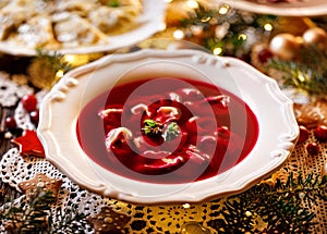 Christmas beetroot soup, borscht with small dumplings with mushroom filling in a ceramic white plate on a holiday table.
