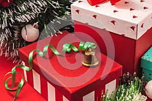 Christmas bell on a background of red beautiful Christmas gifts