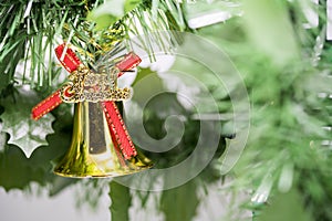 Christmas bell ornament hang on tree branch with green background