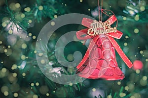 Christmas bell with text merry Christmas and Christmas tree background. Xmas theme