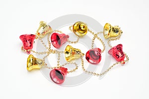 Christmas bells of red and gold color with a chain on a white background