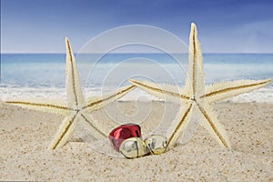 Christmas bells and starfishes on sand