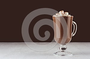 Christmas beverage - hot chocolate in mug with marshmallows, cocoa powder  in elegant dark brown interior, copy space.