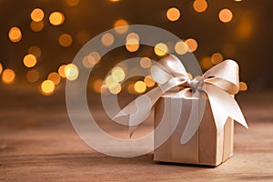 Christmas or birthday gift box against golden bokeh background. Holiday greeting card