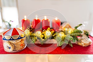 Christmas biscuits and four burning candles on an advents wreath, nice decoration, awaiting the traditional celebrations