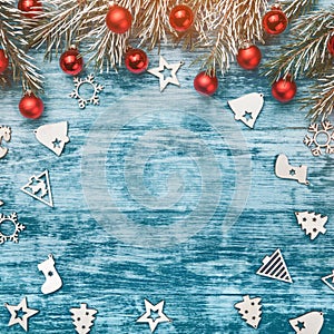 Christmas blue background with decoration, red baubles, wooden ornamented toys and fir tree branch