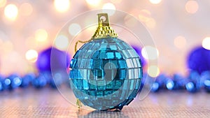 Christmas blue glass ornament for Christmas tree with blinking lights behind
