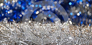 Christmas blue and silver tinsel close-up and swirling bokeh