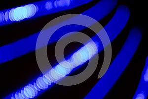 Bokeh blue abstract background with blurred neon light curved lines