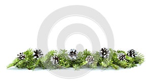 Christmas border arranged with fresh green fir branches and pine cones on white background. Copy space