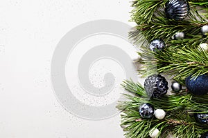 Christmas border with blue balls, evergreen branches on white. Xmas greeting card