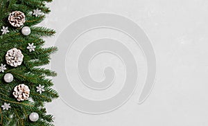 Christmas border with fir branches, cones and silver snowflakes on a grey background. New Year. Greeting card. Copy space, top