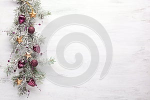 Christmas border with fir branches and  lilac baubles on white shabby wooden board with copy space for text. Flat lay.  Christmas