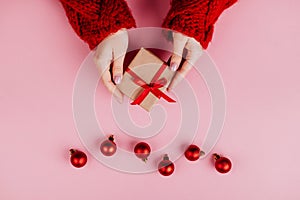 Christmas border with gift boxes, balls, decoration and sequins on pink table top view.