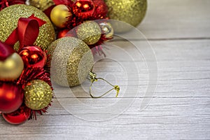Christmas border of gold and red balls on a white wooden background. New year greeting card Copy space