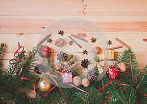 Christmas border made of fir branches, christmas decorations, spices, walnuts and gifts.