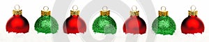 Christmas border of red and green baubles in snow isolated