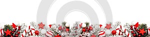 Christmas border of red and white ornaments and frosty branches isolated on white
