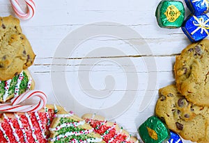 Christmas border of sweets, including cookies, peppermints and chocolates on a rustic wooden background.