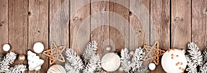 Christmas border of white and gold ornaments with frosty branches on a rustic wood banner background