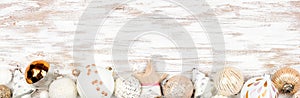 Christmas bottom border of gold, white and blush ornaments on a rustic white wood banner background