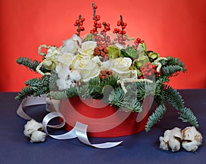 Christmas bouquet of roses and fir branches in a red box