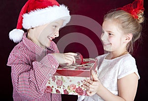 Christmas boy giving present to smiling girl