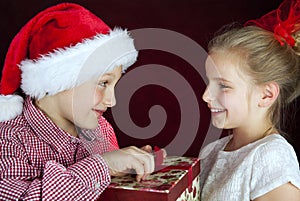 Christmas boy giving present to smiling girl