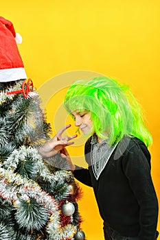 Christmas boy greets the Christmas tree by the hand on the holiday, miracles and magic on New Year`s Eve