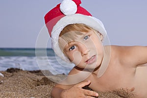 Christmas boy play on the beach