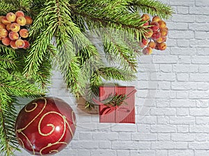 Christmas branch red celebrate box with a bow on a brick background