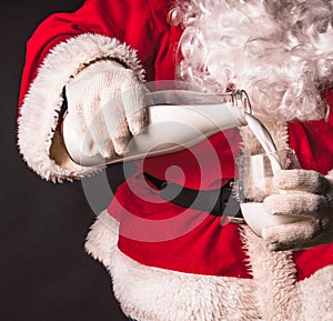 Christmas breakfast. Healthy food. Santa Claus in a traditional costume pours milk from a bottle into a glass