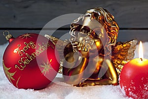Christmas bulb burning candle golden putto on pile of snow