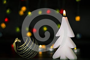 Christmas burning candle on the background of colorful lights garland, bokeh.