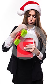 Christmas business Woman open Gift Box with sad emotion. Beautiful Brunette Girl in Santa Hat isolated.