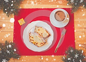 Christmas cake with candied fruits and raison, cup of hot chocolate, gift box and fir branches on wooden table. Top view