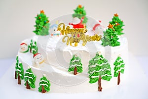 Christmas cake decorated with sweet figures of Christmas tree, Santa and sleigh