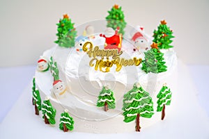 Christmas cake decorated with sweet figures of Christmas tree, Santa and sleigh