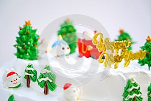 Christmas cake decorated with sweet figures of Christmas tree, Santa and sleigh