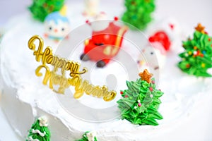 Christmas cake decorated with sweet figures of Christmas tree, Santa and sleigh