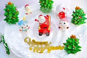 Christmas cake decorated with sweet figures of Christmas tree, Santa and sleigh