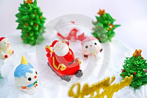 Christmas cake decorated with sweet figures of Christmas tree, Santa and sleigh