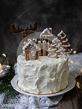 Christmas cake with gingerbread decorations - cookies in shape of homes and snowy trees, moose. Christmas,New Year