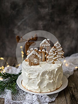 Christmas cake with gingerbread decorations - cookies in shape of homes and snowy trees, moose. Christmas,New Year