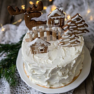 Christmas cake with gingerbread decorations - cookies in shape of homes and snowy trees, moose. Christmas,New Year