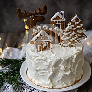 Christmas cake with gingerbread decorations - cookies in shape of homes and snowy trees, moose. Christmas,New Year