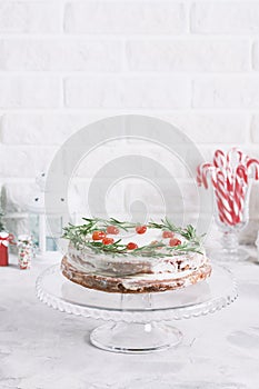 Christmas cake on glass stand decorated with rosemary dried berries