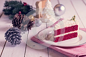 Christmas cake on plate on red fabric on wood background and dec