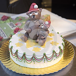 Christmas cake with stars, topped with Teddy in Santa hat holding  teddy's child in arm